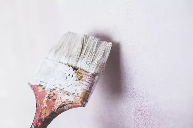 Paint brush positioned against wall